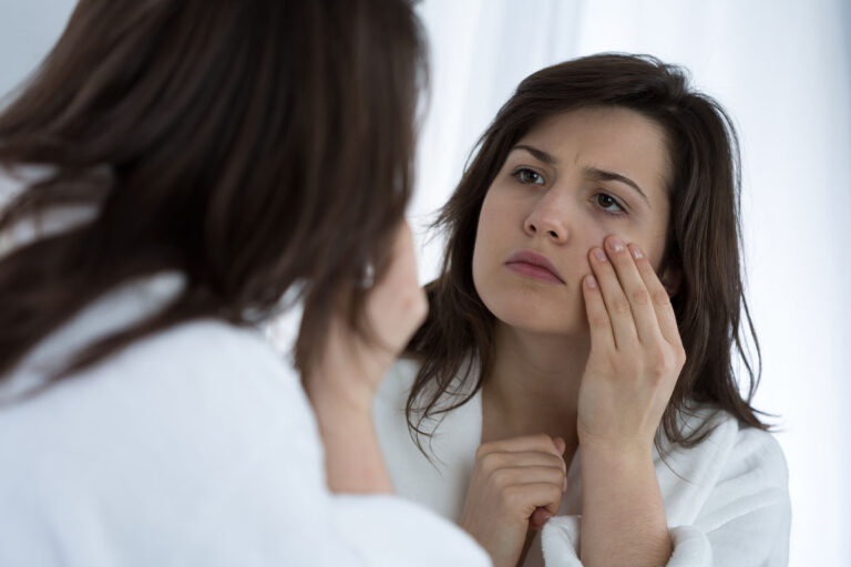 a person checks their eyes in the mirror for signs of heroin abuse