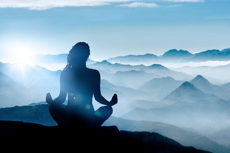 a person practicing the benefits of meditation meditates on a mountain