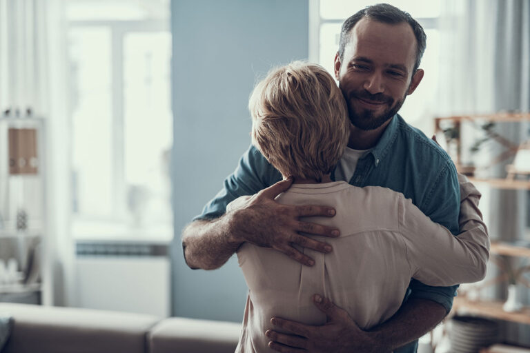 a partner hugs a man in active addiction